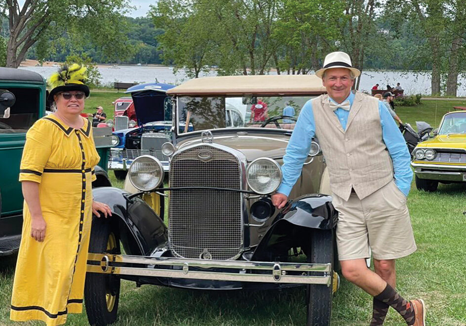 Couple in front of historic car at Yellowstone Heritage Day.