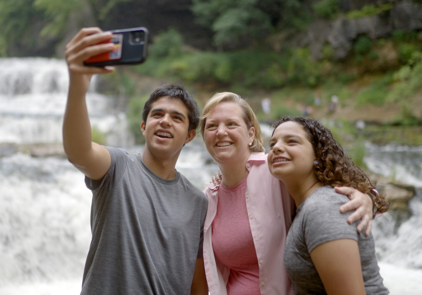 FamilyatFalls_22_web Mother and two teenage children taking a selfie in front of Willow Falls.