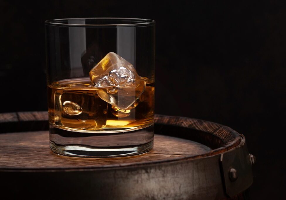 Scotch whiskey glass Scotch whiskey glass and old wooden barrel. With copy space